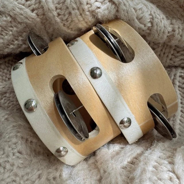 Pair of single row tambourines on a fabric background