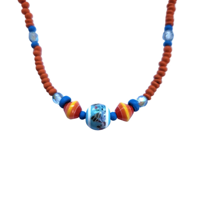 Close up of colorful orange and blue beaded necklace on a white background