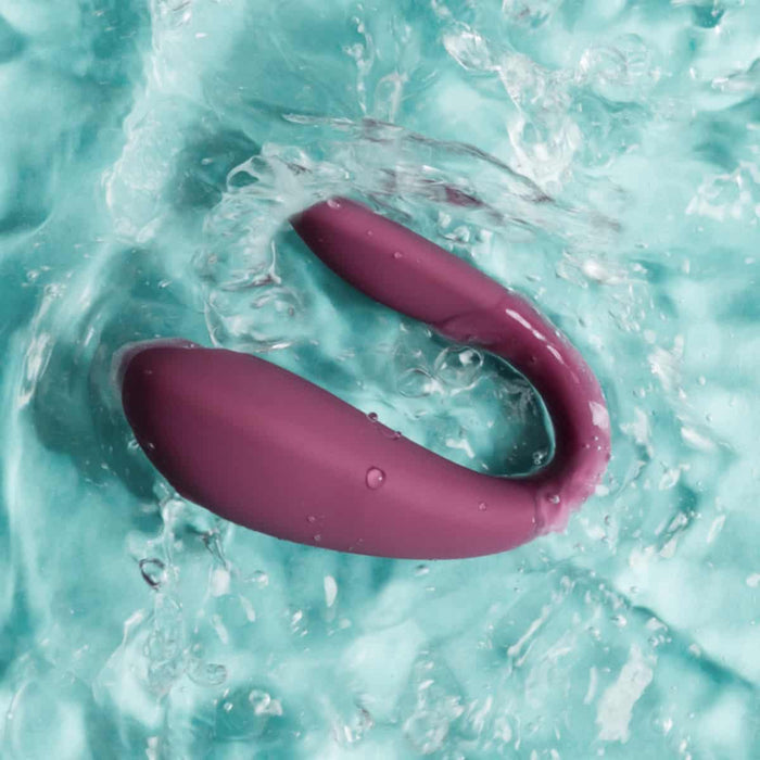 Wearable couple's massager in water with blue background.