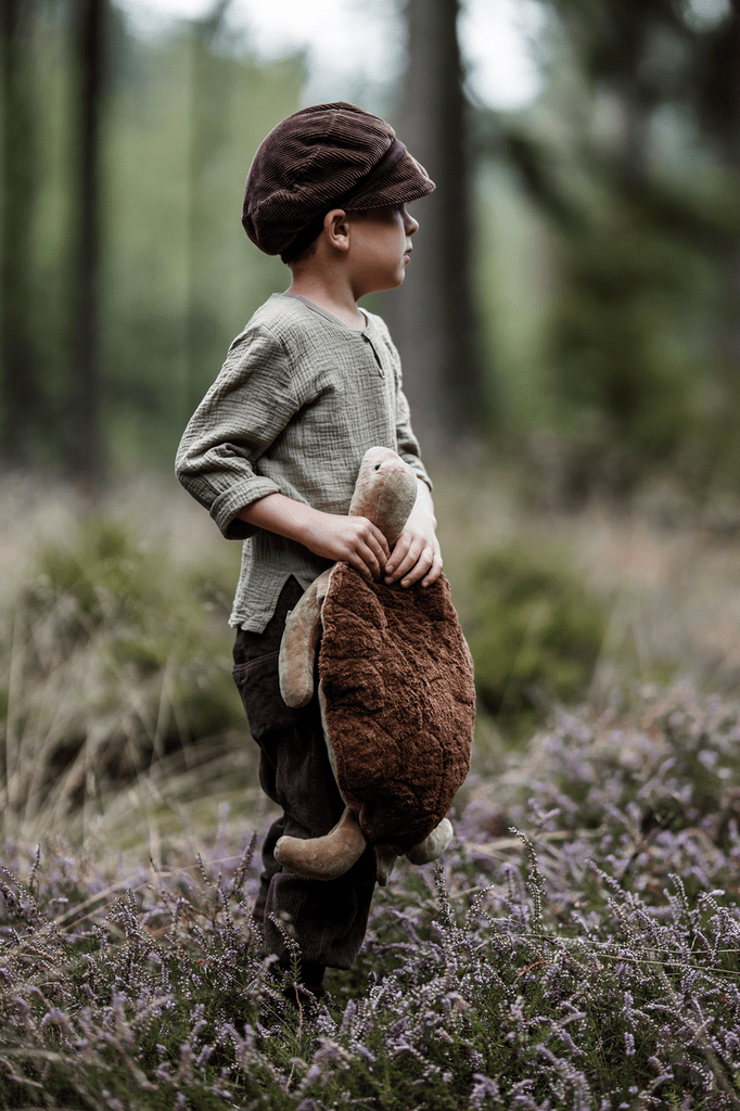 child in the woods with a large senger turtle