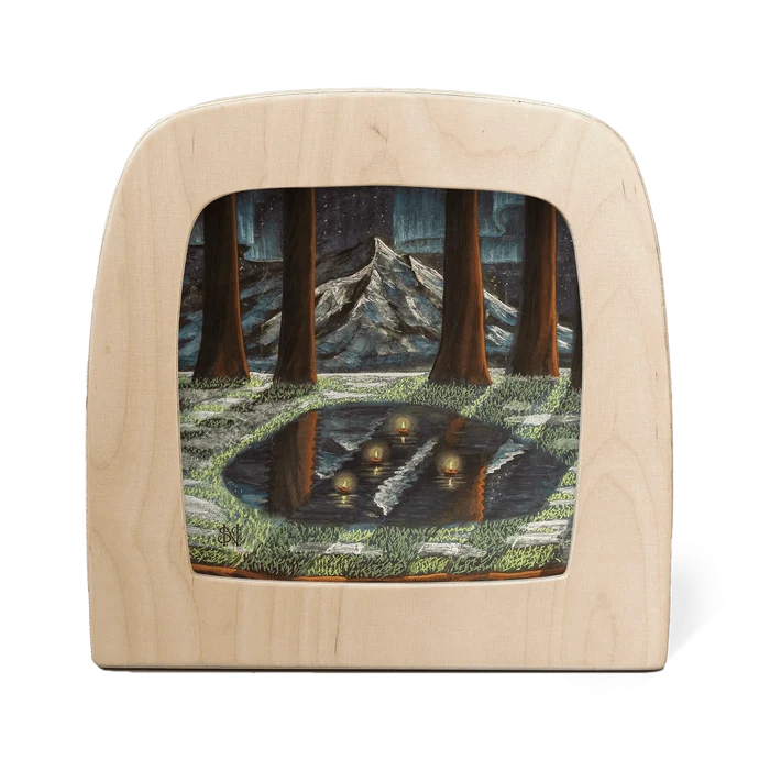 Wooden frame with silhouette of a moonlit forest with melting snow and a mountain landscape and aurora borealis in the background
