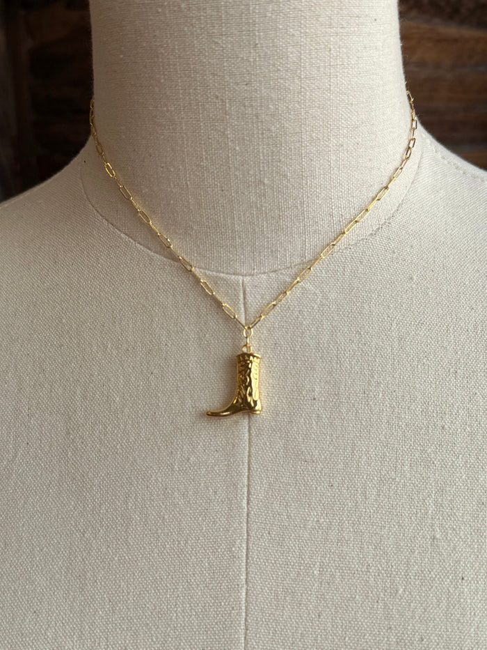 Gold plated cowgirl boot charm pendant on a thin gold chain, close-up