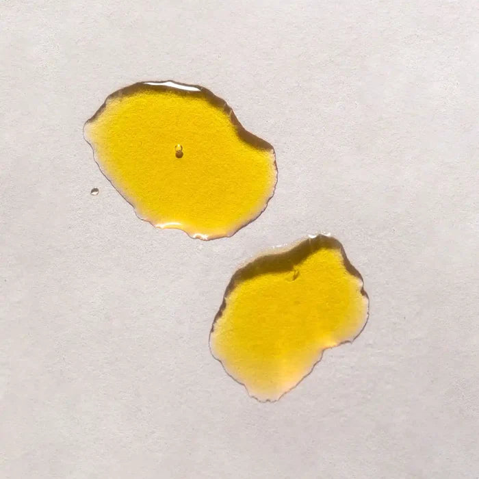 Swatches of facial oil with bright golden yellow colour.