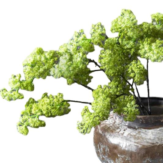 Artificial green plant in a rustic pot on a white background