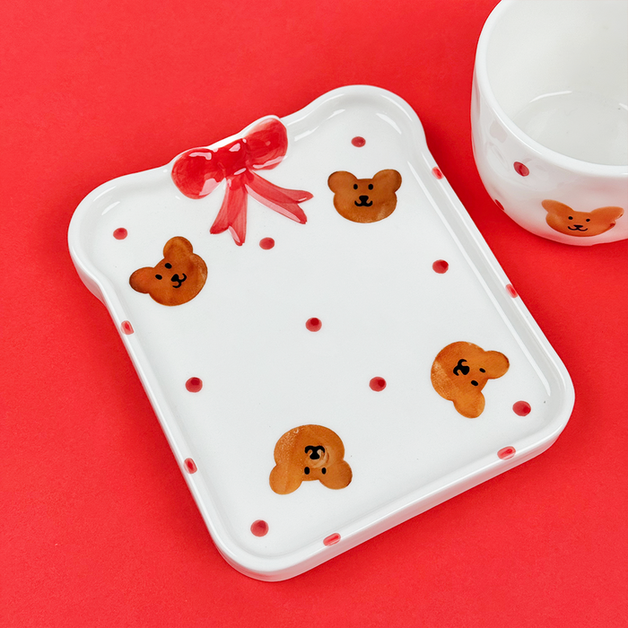 Red ceramic mug and toast plate set with bear faces and scattered red dots.