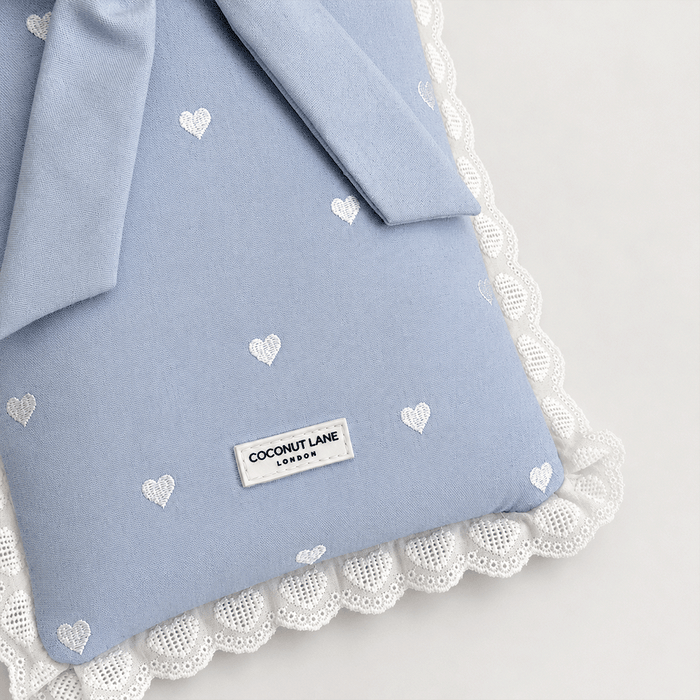 Blue fabric Book Sleeve with embroidered heart design, bow closure and white lace edging.