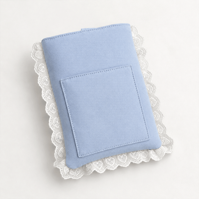 Blue fabric Book Sleeve with embroidered heart design, bow closure and white lace edging.