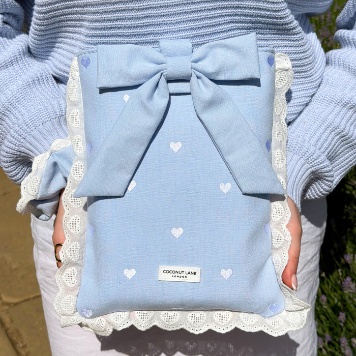 Close up image of girl in the sun holding the Blue Hearts Book Sleeve
