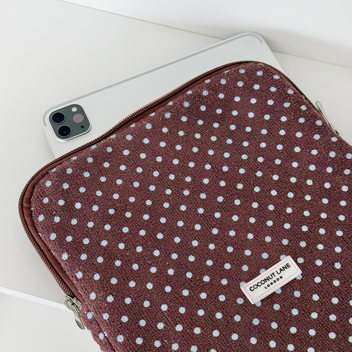 Brown and blue polka dot iPad sleeve holding a tablet on a white surface.
