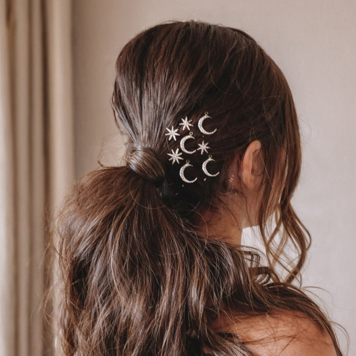 Set of 8 celestial U pins with stars and moons tucked into messy bun for cocktail party look