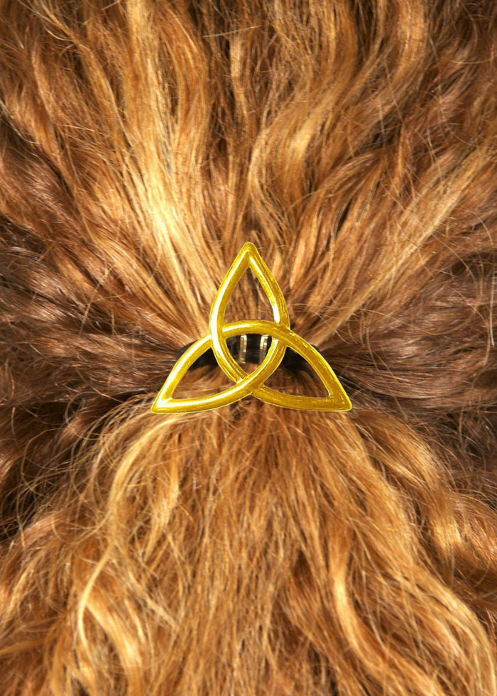 Gold Celtic eternity knot hair hook worn in curly red hair, back view