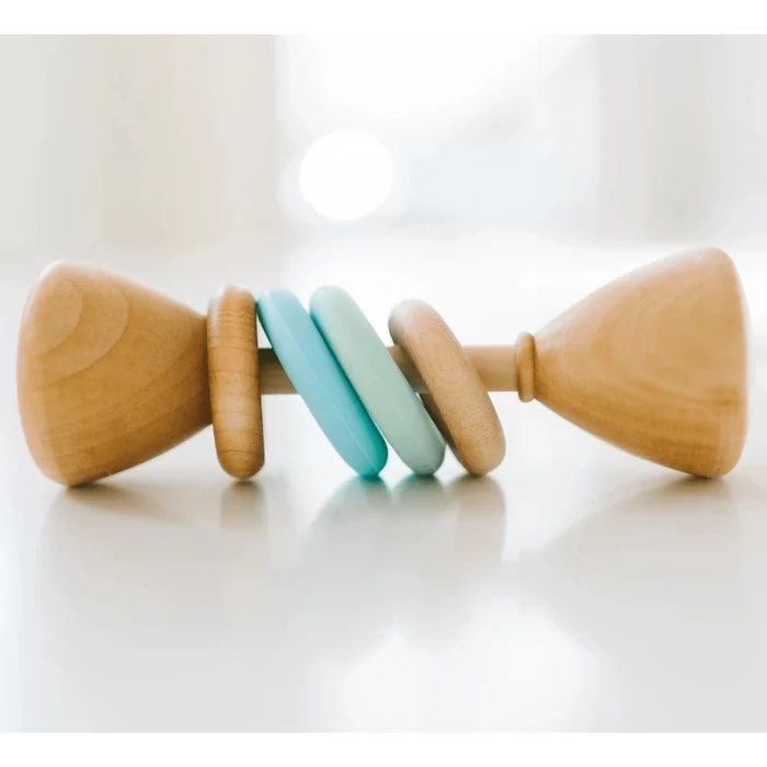 Wooden baby rattle with colorful blue rings on a white surface