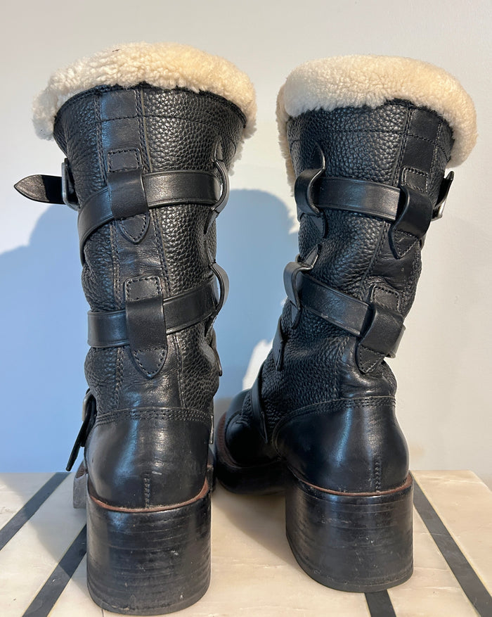 Coach shearling moto boots in size 6.5 with black leather and cozy shearling lining, featuring buckle details and rugged sole.