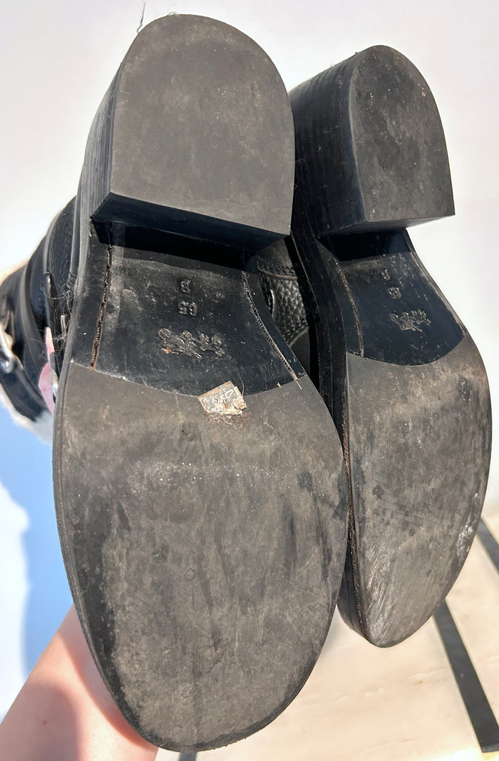 Coach shearling moto boots in size 6.5, featuring black leather with plush shearling lining and rugged sole detail.