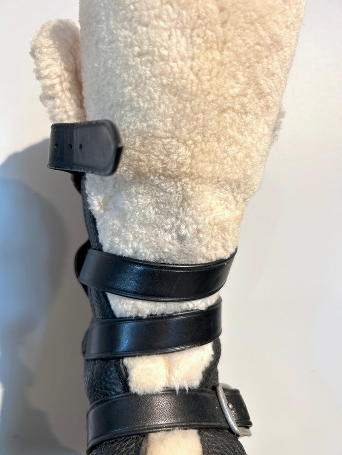 Coach shearling moto boots in size 6.5, featuring black leather and cozy shearling lining, shown from a front angle.
