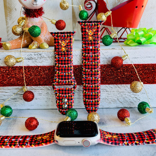 Close-up of Deerlightful reindeer print with festive lights on red and black buffalo check Apple Watch silicone band