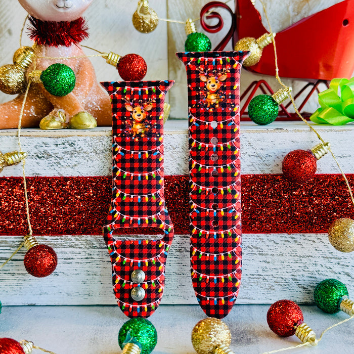 Close-up of Deerlightful reindeer print with festive lights on red and black buffalo check Apple Watch silicone band