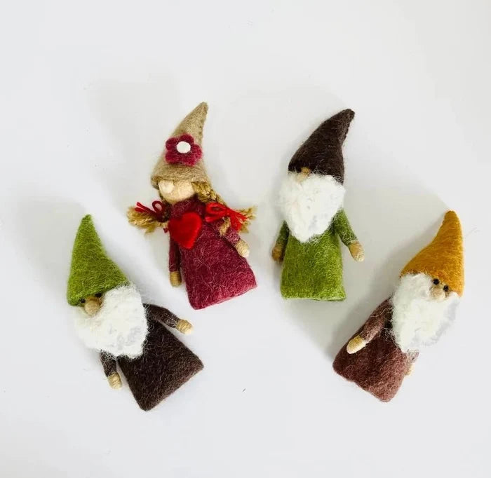 Four small gnome finger puppets with different hairstyles and outfits on a white background