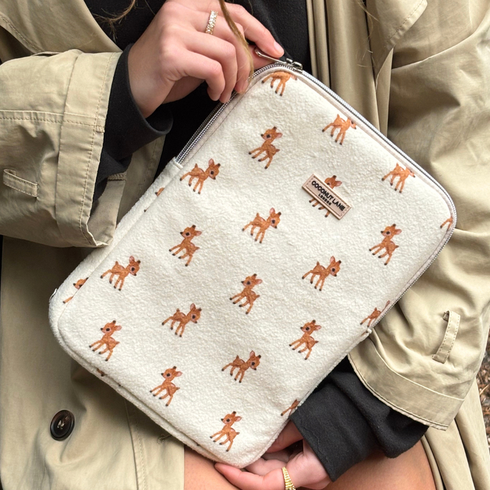 Coconut Lane Fleecy Fawn iPad Sleeve with Bambi print held by person in tan trench coat and black top.