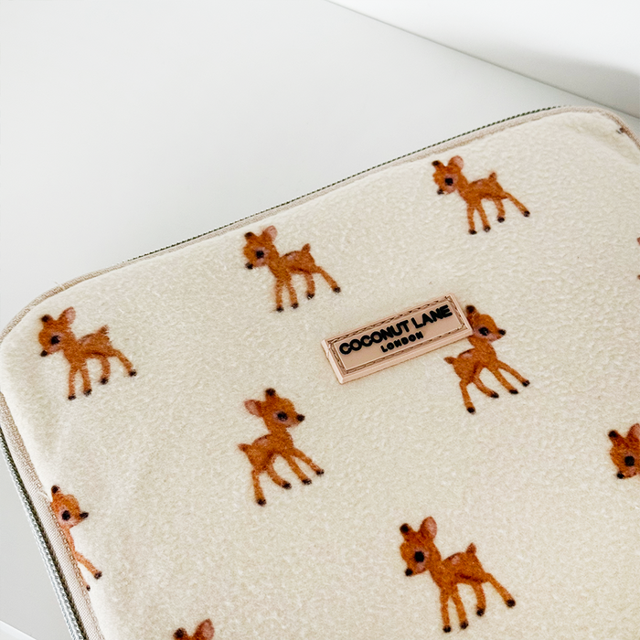 Cream fleecy iPad sleeve with small brown deer pattern and a Coconut Lane brand label in the center.