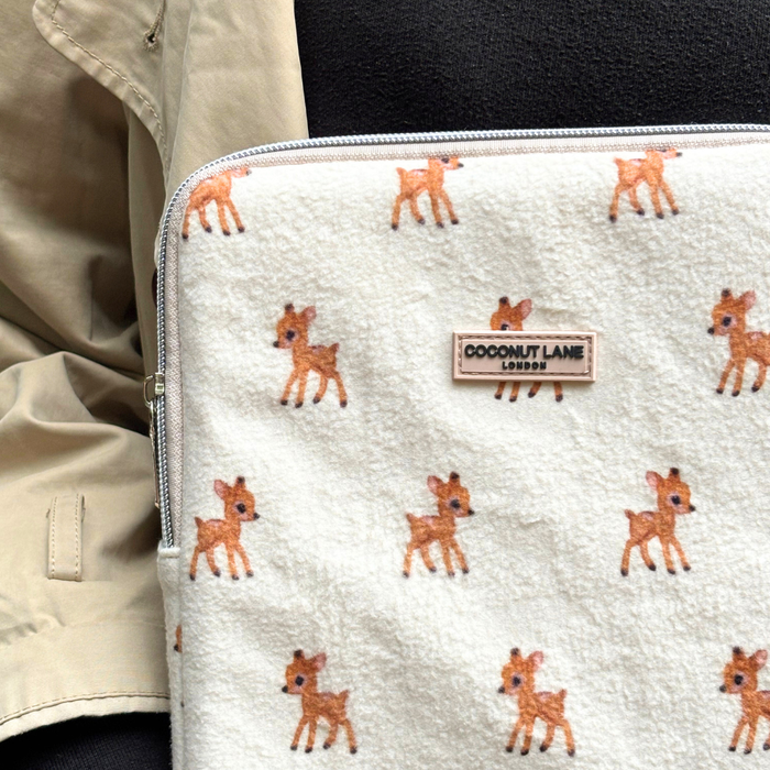 Cream fleecy iPad sleeve with small deer prints, next to a beige coat.