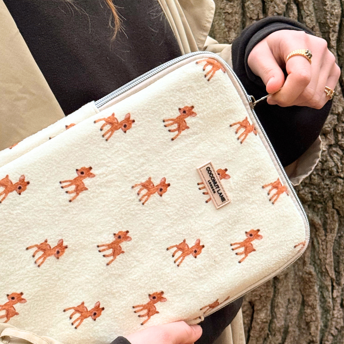 Coconut Lane iPad sleeve with fluffy cream fabric, cartoon deer design, and a COTTON FLUFFY label held by a person.