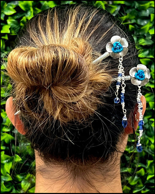 Model wearing Flower & Bead Hair Sticks with blue floral accents and dangling beads in a bun hairstyle.