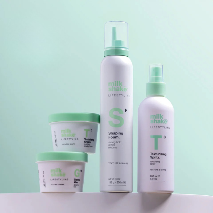 Set of milk_shake volumising products with green and white packaging on a light green background.