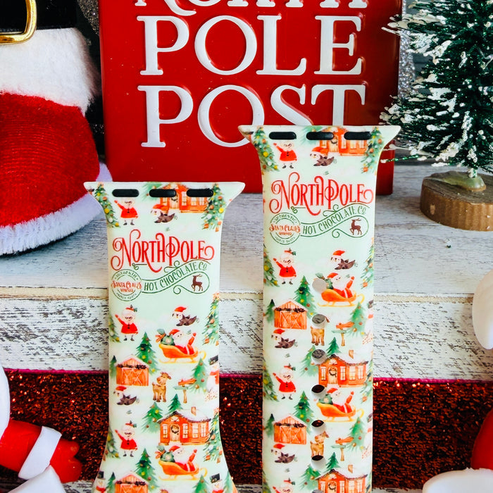 North Pole Apple Watch band with Santa's workshop, Christmas trees, and reindeer on cream background with North Pole sign