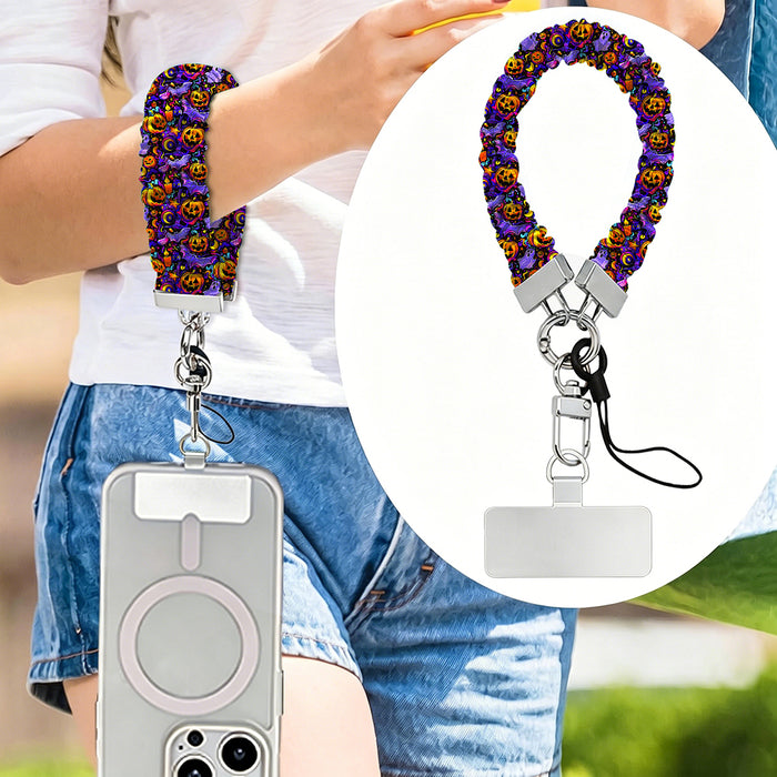 Jack-O-Lantern Jive scrunchie phone wrist strap worn on the wrist and clipped at the hip, with a close-up of the purple neon pumpkin print.