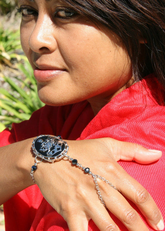 Model wearing kingdom crest finger bracelet with chain, gold-tone festival jewelry, lifestyle view