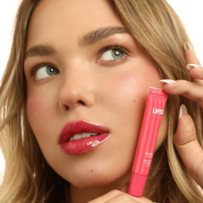 Woman applying pink lip gloss Lipss Raspberry Gelato to her lips with a close-up of the product.
