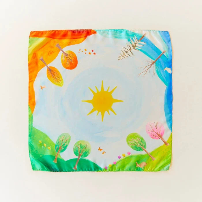 Colorful silk with a sun, trees, and flowers design on a white background