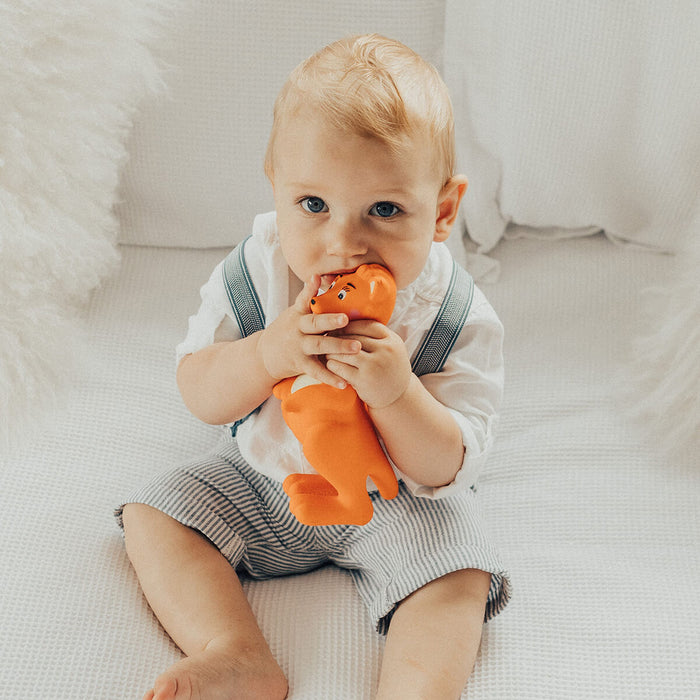 Baby holding Mizzie The Kangaroo Teething Toy, an award-winning, natural teething toy specifically designed to support babies. Made from 100% natural rubber and water-based, non-toxic dyes.