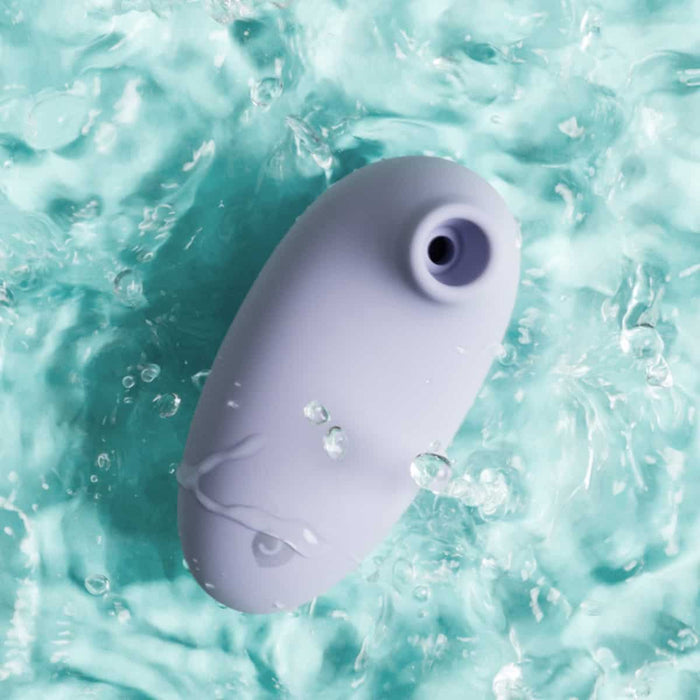 Purple air suction stimulator in water with blue background.