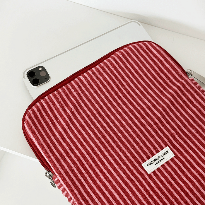 Tablet partially in a striped, towel-texture iPad sleeve with mulberry tones on a white surface.