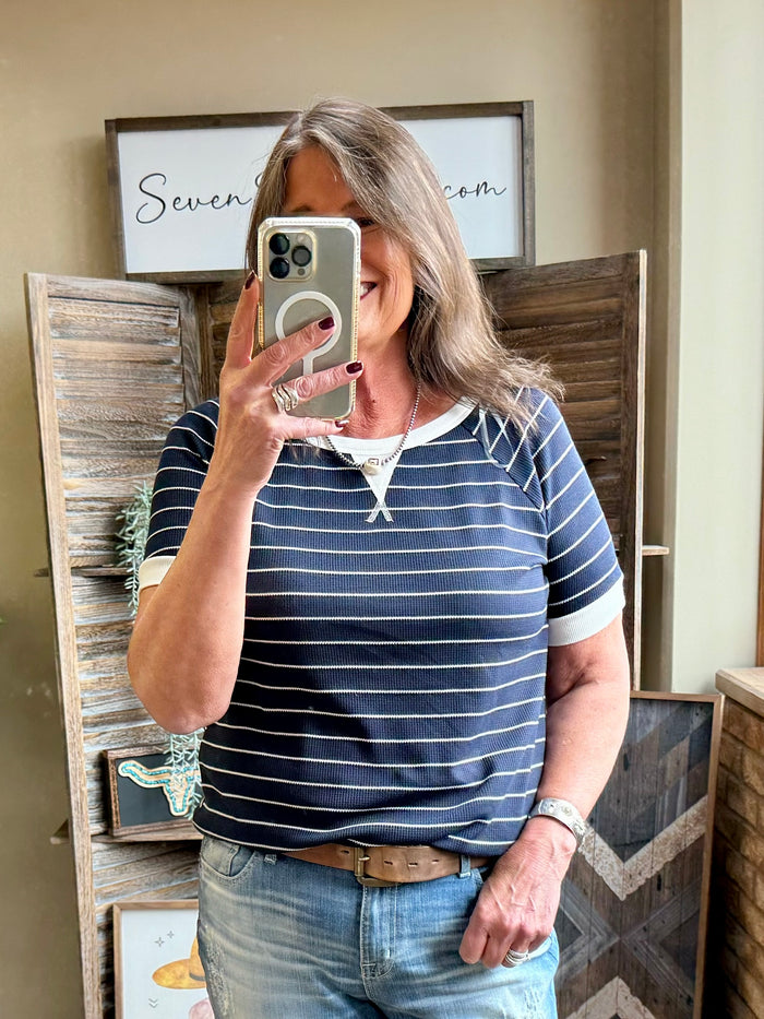 Navy striped T-shirt with white V-neck trim and short sleeves