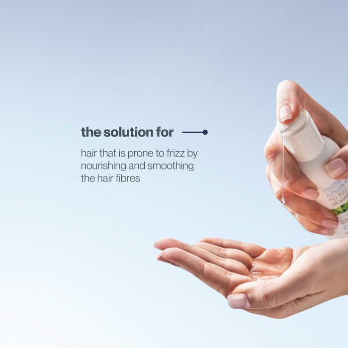 Hand holding a bottle of milk_shake glistening serum with text on a light blue background