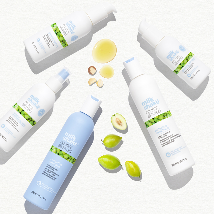 Multiple bottles of milk_shake no frizz allowed products on a white background with green and blue elements.