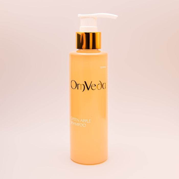 OmVeda Green Apple Shampoo pump bottle with white pump and gold collar; amber bottle