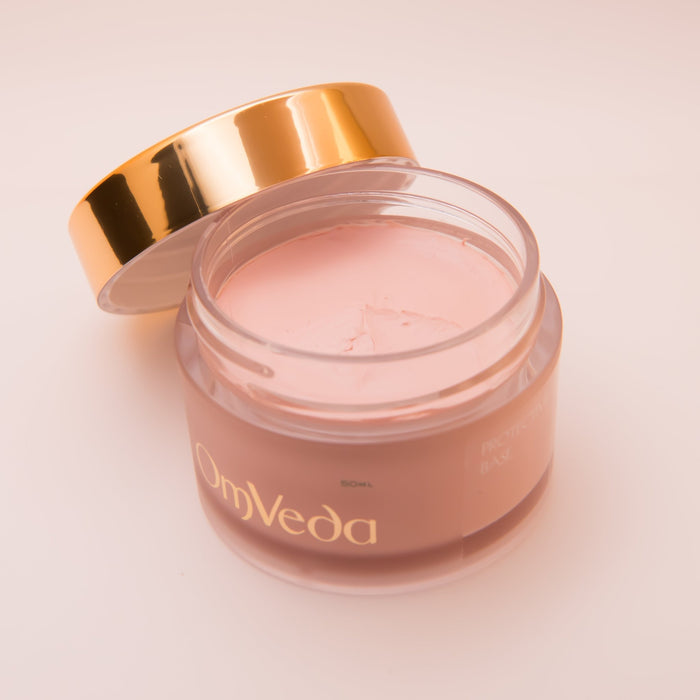 Protective base moisturizer jar with open gold lid, pink cream inside, 50 ml