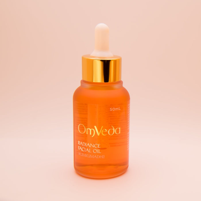 OmVeda Radiance Kumkumadi Facial Oil 50ml amber bottle with white dropper and gold cap.
