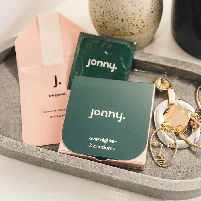 Jonny Overnighter 3 Pack vegan condoms on a tray with jewellery.