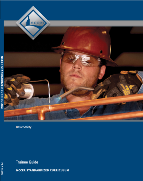 Cover of NCCER Basic Safety Trainee Guide showing a worker with hard hat and gloves soldering copper pipes