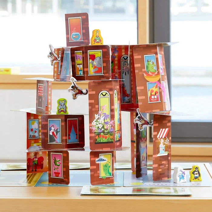 Game pieces from Rhino Hero Super Battle stacked high on a table in front of a window
