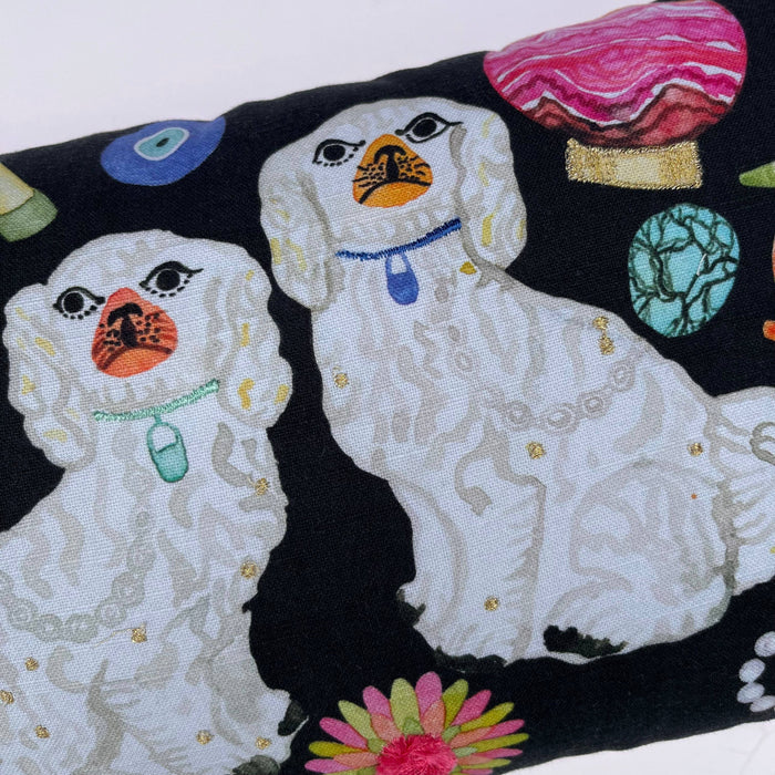 Embroidered design of two dogs on a black background with colorful elements.