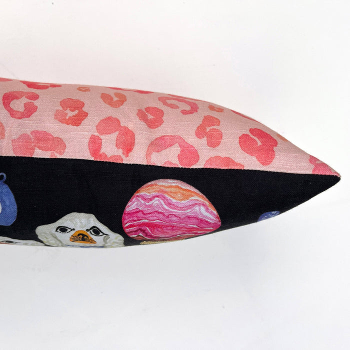 Decorative pillow with pink leopard print and colorful animal design on a white background