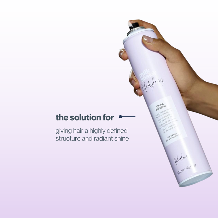 Hand holding a milk_shake hair spray can with text on a light purple background