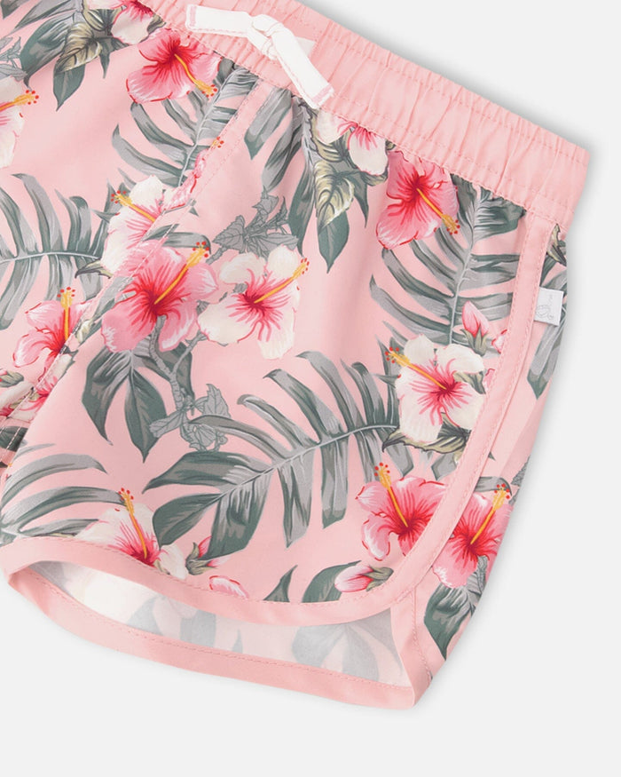 Close-up of hibiscus print, contrast binding, and drawstring waist on pink swim shorts