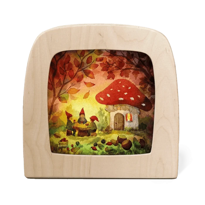 Silhouette of three gnomes sitting at a table outside of their mushroom home enjoying a picnic